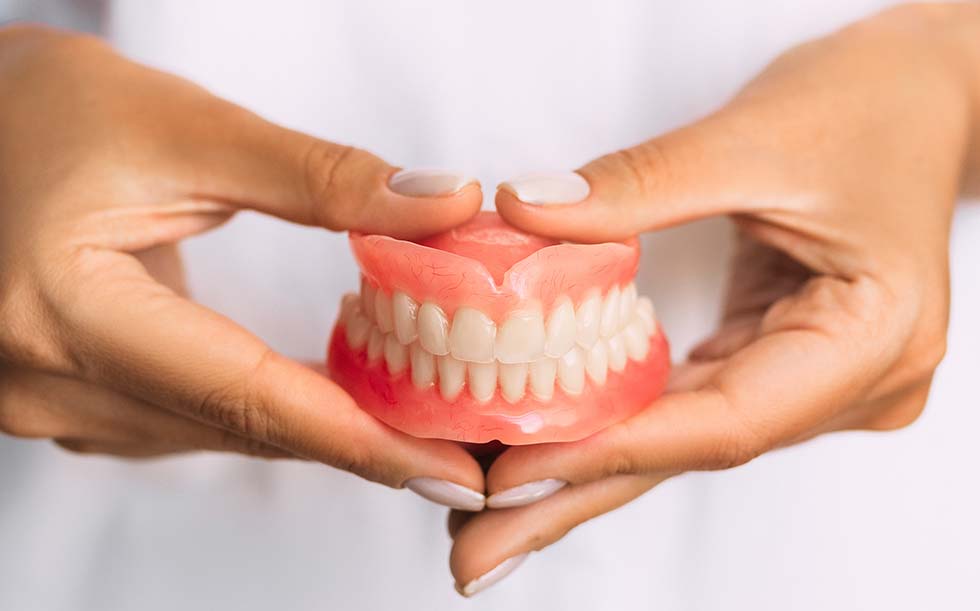 Close up of dentures in hands | Family Dentistry in Texarkana, TX